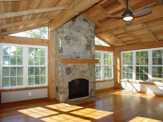 Rustic-Sunroom-with-Stone-Fireplace-and-Wooden-Roof
