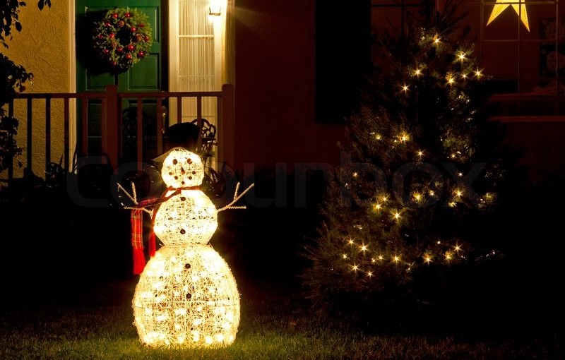 -christmas-decorations-snowman-and-christmas-tree-with-lights-on-green-grass