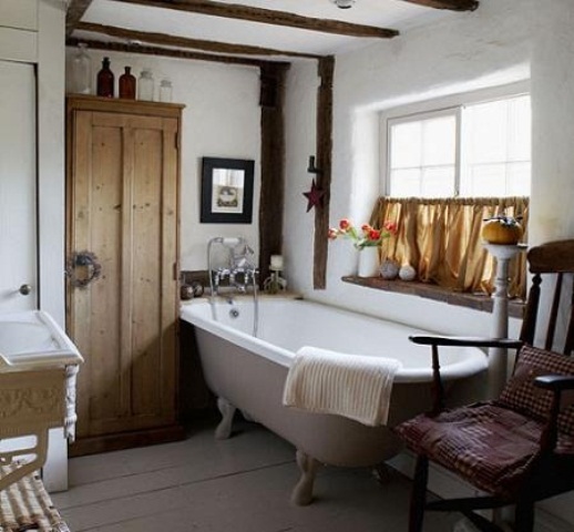 White cottage rustic bathroom oak wood ceiling beams freestanding roll top bath painted floorboards antique wardrobe window with half curtain real home CH&I 11/2009 pub orig